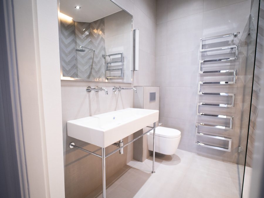 Badezimmer mit bodengleicher Dusche, Waschtisch und Handtuchheizkörper